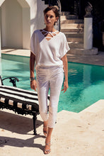 Load image into Gallery viewer, These high-quality denim jeans feature a classic and elegant design with a shimmering foil animal print. The slim crop silhouette provides versatility, while the hidden elastic waistband ensures comfort and security. Color- White and silver. Foiled twill. Hidden elastic waistband. Two back pockets. Unlined.