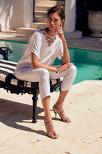 Load image into Gallery viewer, These high-quality denim jeans feature a classic and elegant design with a shimmering foil animal print. The slim crop silhouette provides versatility, while the hidden elastic waistband ensures comfort and security. Color- White and silver. Foiled twill. Hidden elastic waistband. Two back pockets. Unlined.