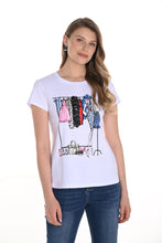 Load image into Gallery viewer, This fun fashion tee is a vibrant and stylish addition to your wardrobe. This knit top features a lively white and multi-color print of a stylish lady standing next to a rack of stylish apparel and shoes/purses. A soft fabrication provides ultimate comfort and style. The design is perfect for brightening up your casual or work attire, and it pairs effortlessly with jeans, trousers, or skirts and is so stylish when worn under a blazer or favorite jacket.