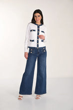 Load image into Gallery viewer, Woman wearing a white cardigan with blue accents, blue wide leg jeans with gold buttons and white sandals on a white background.