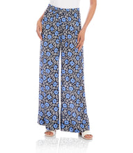 Load image into Gallery viewer, Woman wearing blue floral wide-leg pants and white sandals on a white background.