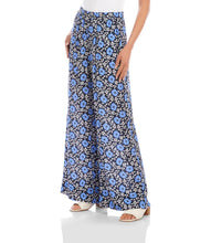 Load image into Gallery viewer, Woman wearing blue floral wide-leg pants and white sandals on a white background.
