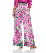Load image into Gallery viewer, The Wyndy Wide Leg Pants in Pink and Green Multicolor Print by Karen Kane are stylish wide-leg pants featuring a striking Italian tile border print on smooth crepe fabric. They are fitted at the waist and relaxed at the hips, offering a comfortable drape with a pull-on elastic waistband and functional side pockets. Ideal for pairing with solid tops or matching prints, these wide-leg pants can be dressed up with heels or kept casual with sandals.