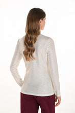 Load image into Gallery viewer, Woman wearing a white sparkle long sleeve top and red pants against a white background.