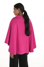 Load image into Gallery viewer, Woman wearing a bright pink cape and black pants against a white background.