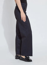 Load image into Gallery viewer, Model wearing dark plaid pants and black loafers against a white background.