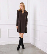 Load image into Gallery viewer, Woman wearing a brown dress and black knee-high boots against a white paneled wall.