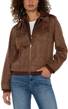 Load image into Gallery viewer, Introducing our new trucker jacket, complete with a detachable hood. The rich, earthy hue enhances the faux leather material, adding a layer of sophistication. This versatile and chic jacket is an indispensable addition to the wardrobe of any contemporary explorer.