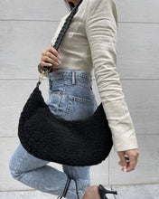 Load image into Gallery viewer, The unique moon-shaped Zola bag is now accented with a Vegan Sherpa Body adding the perfect amount of texture to your everyday bag! This bag has a curved silhouette and is accented with an adjustable braided vegan leather strap. Including a pull zipper closure on the top of the bag, interior zip, and open interior pockets. Wear the Zola as a crossbody with its adjustable braided strap or as a shoulder bag. Color- Black.