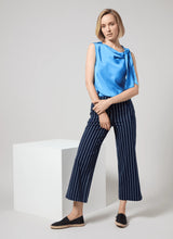 Load image into Gallery viewer, The Zulena Bow-Tie Neck Top in vibrant Electric Blue is a true wardrobe essential for fashion-forward individuals. Designed with a straight, cropped fit that runs true to size, this sleeveless top is crafted from luxurious Soft Touch Satin for a smooth, elegant feel. Cut on the bias for a flattering drape, it features stylish details such as a diagonal back seam, chic side slits, and an adjustable shoulder tie, making it the perfect blend of comfort and sophistication.
