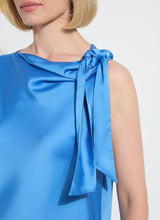 Load image into Gallery viewer, The Zulena Bow-Tie Neck Top in vibrant Electric Blue is a true wardrobe essential for fashion-forward individuals. Designed with a straight, cropped fit that runs true to size, this sleeveless top is crafted from luxurious Soft Touch Satin for a smooth, elegant feel. Cut on the bias for a flattering drape, it features stylish details such as a diagonal back seam, chic side slits, and an adjustable shoulder tie, making it the perfect blend of comfort and sophistication.