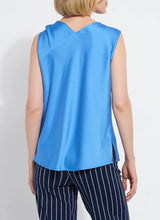 Load image into Gallery viewer, The Zulena Bow-Tie Neck Top in vibrant Electric Blue is a true wardrobe essential for fashion-forward individuals. Designed with a straight, cropped fit that runs true to size, this sleeveless top is crafted from luxurious Soft Touch Satin for a smooth, elegant feel. Cut on the bias for a flattering drape, it features stylish details such as a diagonal back seam, chic side slits, and an adjustable shoulder tie, making it the perfect blend of comfort and sophistication.