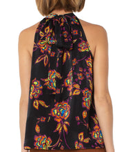 Load image into Gallery viewer, A beautiful black base with vibrant neon floral pattern in lime green, yellow, purple, turquoise and orange creates a stunning mock neck top. A dramatic finishing touch is a tie at the base of the neck. With a fabric that is soft and cool to the touch, you will not only be stylish but comfortable at the same time.