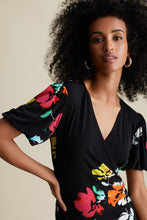 Load image into Gallery viewer, Joseph Ribkoff is known for modern and stylish pieces that are beyond gorgeous and this Aria dress fits all of those qualities and more! A striking floral pattern in various shades of blue, white, orange, yellow and red comes alive on a beautiful black background. A beautiful V-neck is highlighted with a crossover design leading to rouching at the side. A billowy sleeve adds to the attractiveness. For so many dazzling moments in your life, this is the dress of choice!