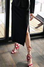 Load image into Gallery viewer, Our black knit long skirt by Frank Lyman is a gorgeous addition to your wardrobe as it pairs perfectly with a number of tops. A classic piece, our Bristol skirt is a flattering style with a side slit, giving it a sophisticated feel.