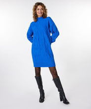 Load image into Gallery viewer, A piercing bright blue color dazzles on this mesmerizing Bettina dress. The classic cable pattern and ribbed cuffs, along with a slightly oversized fit, creates a style that will become your next fashion favorite. Our Bettina is a beautiful piece to style with leggings and boots or choose to wear alone with boots or heels. Color- Blue. Pull-over style. Mock-neck. Ribbed cuffs.