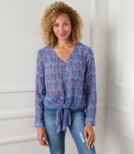 Load image into Gallery viewer, Various floral and shapes print in colorful blue and red hues brings this figure flattering tie front top to life. The addition of shimmering metallic lurex makes it the perfect way to dress up any outfit. Color- Red and blue. Long sleeve button cuff. V-neck. Tie-front.