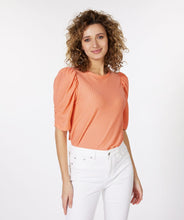 Load image into Gallery viewer, Our Brittany short sleeve top in a brilliant bright peach color will become your next wardrobe favorite. Designed with just the right amount of ruffle sleeve to create a fashionable look, the Brittany includes a beautiful textured fabric. This top pairs with almost any bottom, and looks stunning when worn with our GLORIA GROOVY PRINT WIDE LEG PANT - ESQUALO. Color- Bright peach. Pull-over. Ruffle sleeve design. Textured fabric. Short-sleeve. Stretch fabrication. Slightly sheer.