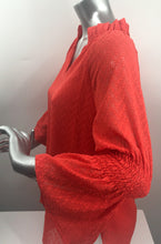 Load image into Gallery viewer, Our Carissa long sleeve top offers a feminine flair with its Swiss dot fabrication, elasticized sleeves and ruffle V-neck design. While the gorgeous sleeves are slightly sheer, the bodice is fully lined. Wear with your favorite denim or dress up with a pair of white or black pants. Color - Coral. Long, sheer sleeves. Fully lined bodice. Ruffle V-neck. Swiss Dot fabrication.