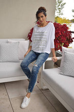 Load image into Gallery viewer, This stylish jean features tasteful embellishments and strategic distressing, resulting in a trendy yet refined appearance. French text and scattered crystals add a touch of visual interest, while subtle distressing at the knee and ankles provides a subtle hint of edge.