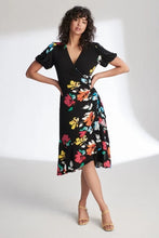 Load image into Gallery viewer, Joseph Ribkoff is known for modern and stylish pieces that are beyond gorgeous and this Aria dress fits all of those qualities and more! A striking floral pattern in various shades of blue, white, orange, yellow and red comes alive on a beautiful black background. A beautiful V-neck is highlighted with a crossover design leading to rouching at the side. A billowy sleeve adds to the attractiveness. For so many dazzling moments in your life, this is the dress of choice!