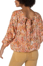 Load image into Gallery viewer, Make a statement in this gathered hem dolman tie back top in a beautiful kaleidoscope print. Perfect for brunch or special occasions. Pairs beautifully with denim or a colored crop! Color-Kaleidoscope; neon coral, vibrant teal green, cream and light brown. 24" HPS Beautiful back tie closure. Dolman sleeves. Gathered hem.