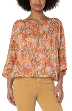 Load image into Gallery viewer, Make a statement in this gathered hem dolman tie back top in a beautiful kaleidoscope print. Perfect for brunch or special occasions. Pairs beautifully with denim or a colored crop! Color-Kaleidoscope; neon coral, vibrant teal green, cream and light brown. 24" HPS Beautiful back tie closure. Dolman sleeves. Gathered hem.
