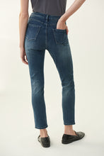 Load image into Gallery viewer, Inspired by the 60's model Twiggy, the Brielle Jean with Sparkle Face Design is truly a work of art that you can wear. This beautiful and comfortable ankle length, classic slim blue jean has a partial female face design on the left leg created with a series of gorgeous sparkling black crystals. You will definitely receive numerous compliments when you wear this work of art. Color- Blue with black crystals.