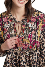 Load image into Gallery viewer, A colorful and fun pattern print comes alive on this dolman sleeve blouse. A bold abstract print combines with a leopard print to create a uniquely beautiful design. The Trisha long sleeve blouse is a perfect top to dress up or wear casually with jeans. Any way you decide to style this gorgeous top, you will definitely stand out as a fashionista! Color- Taupe grey, pinks, gold, red. Dolman sleeve. Self-tie at neck. Multi print. Pop-over notch neck with tassel trim. Flowy fit.