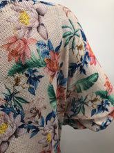 Load image into Gallery viewer, A perfect style to include in your wardrobe, this lightweight sweater is so versatile! Wear as a sweater dress or pair with your favorite bottoms and style as a tunic. Lightweight enough for the spring/summer but also a perfect weight to keep you warm in the fall/winter. A beautiful vibrant flower really pops on the beige background! Colors- Green, pink, orange, yellow, blue and beige. Lightweight knitted sweater. Long sleeve.