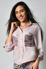 Load image into Gallery viewer, A little edge, a little sass and a lot of class is our Bella Pink Sparkle Blouse by Frank Lyman. The uniqueness is in the details and this gorgeous blouse has many. The left pocket is covered in sparkling pink beading with the words, Eternal, Love, Sweet, Toujours, Passion, Amore, Live, Laughter and more. The printed words and hearts dance on and around the pocket. The right pocket sparkles in pink beading and has a bar of clear and black crystals in a checkered pattern.