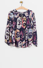 Load image into Gallery viewer, A striking vintage pattern creates an eye-appealing design on this flowy peasant shirt silhouette. Modern details like an elastic cuff and smock detailing ad even more beauty to this gorgeous top. The fabric used to create our Misty has been mindfully made from EcoVero rayon that uses sustainable material and less water. Color-Indigo Mix- Navy, light blue, coral, tan, white, yellow, purple. Woven top. Relaxed fit. Split neck. 3/4 sleeve. Basic sleeve. Tie front. Sits at hip.