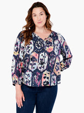 Load image into Gallery viewer, A striking vintage pattern creates an eye-appealing design on this flowy peasant shirt silhouette. Modern details like an elastic cuff and smock detailing ad even more beauty to this gorgeous top. The fabric used to create our Misty has been mindfully made from EcoVero rayon that uses sustainable material and less water. Color-Indigo Mix- Navy, light blue, coral, tan, white, yellow, purple. Woven top. Relaxed fit. Split neck. 3/4 sleeve. Basic sleeve. Tie front. Sits at hip.