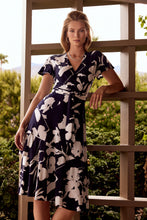 Load image into Gallery viewer, An elegant dress, our Melinda fit and flare dress is a flattering design in a brilliant midnight blue and vanilla color. Featuring a flattering cross-over front, elastic tie waist double frill hemline and frill cap sleeves this dress has elegant movement and is attractive on all figures.