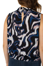 Load image into Gallery viewer, This beautiful floating ink printed top in nautical blue, black, white and soft pink is a fabulous statement piece featuring a mock neck slit and smocked waistband. With a great fit, providing all day comfort, our Mandi can be worn alone or under your favorite jacket or blazer. An outstanding outfit includes this top paired with your favorite white bottom. Color- Floating Ink; Blue, black, white and soft pink. Split front. Sleeveless. Banded elastic bottom. Blousy design. Not stretch fabrication.