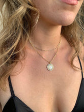 Load image into Gallery viewer, This gorgeous Mother Mary Necklace features a silhouette of Mary in genuine mother of pearl in a gold setting surrounded by cubic zirconia baguette accents. Pendant hangs from a drawn cable chain.