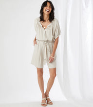 Load image into Gallery viewer, Casual yet polished, the Karen Kane Penelope Paperbag Waist Shorts feature a stylish ruffled paperbag waist with a belted tie and elastic waistband for adjustable comfort. Crafted from a soft linen-rayon blend, these shorts offer a relaxed fit and mid-thigh length, making them perfect for warm-weather outings. Front pockets add practicality to their chic design, while the natural beige color ensures versatile styling.