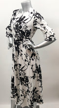 Load image into Gallery viewer, Every fabulous woman needs a black and white dress to showcase her beauty and our Vivien Black and White Floral Mid Length Dress by Papillon is the perfect dress to do just that. Whether you are going to a garden party, a wedding or a lovely dinner, this dress will make you feel like royalty. Colors- Black and White floral. Tie waist belt. Mid length.