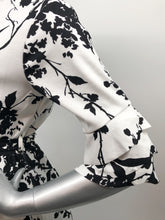Load image into Gallery viewer, Every fabulous woman needs a black and white dress to showcase her beauty and our Vivien Black and White Floral Mid Length Dress by Papillon is the perfect dress to do just that. Whether you are going to a garden party, a wedding or a lovely dinner, this dress will make you feel like royalty. Colors- Black and White floral. Tie waist belt. Mid length.