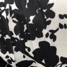 Load image into Gallery viewer, Every fabulous woman needs a black and white dress to showcase her beauty and our Vivien Black and White Floral Mid Length Dress by Papillon is the perfect dress to do just that. Whether you are going to a garden party, a wedding or a lovely dinner, this dress will make you feel like royalty. Colors- Black and White floral. Tie waist belt. Mid length.