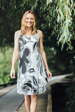 Load image into Gallery viewer, A classic dress, this black, white and gray biased cut dress will easily become your next favorite. A lovely abstract floral pattern adorns this two-tier hem dress and with the sleeveless design, you can easily style with a cardigan or jacket. Fully lined.