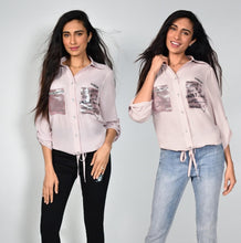 Load image into Gallery viewer, A little edge, a little sass and a lot of class is our Bella Pink Sparkle Blouse by Frank Lyman. The uniqueness is in the details and this gorgeous blouse has many. The left pocket is covered in sparkling pink beading with the words, Eternal, Love, Sweet, Toujours, Passion, Amore, Live, Laughter and more. The printed words and hearts dance on and around the pocket. The right pocket sparkles in pink beading and has a bar of clear and black crystals in a checkered pattern.