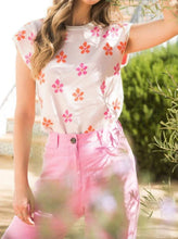 Load image into Gallery viewer, Pretty in pink describes how you'll feel when you put on this lovely short sleeve top. A beautiful true pink base has pops of bright orange and fuchsia flower motifs. The sleeves, neckline and bottom include a contrast ribbed trim in white creating even more interest. A perfect top to pair with shorts or jeans or wear under a jean jacket, you cannot go wrong with this adorable top.