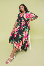 Load image into Gallery viewer, The Ellie Woven Maxi Dress is so stunning with a black background and a floral print that just pops! This gorgeous style features a surplice neckline and is a true wrap design with a ruffled hemline. A dress for those perfect moments in your life.