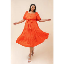 Load image into Gallery viewer, Our India dress is a dress you will want to wear for so many special occasions. This amazing woven midi dress features a square neckline, with non-functional button -down detail, a self-sash tie, elasticized waist and sleeves at shoulders and arm and tiered skirt. A rich coral color makes this dress even more stunning.