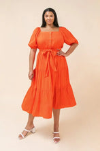 Load image into Gallery viewer, Our India dress is a dress you will want to wear for so many special occasions. This amazing woven midi dress features a square neckline, with non-functional button -down detail, a self-sash tie, elasticized waist and sleeves at shoulders and arm and tiered skirt. A rich coral color makes this dress even more stunning.