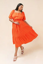 Load image into Gallery viewer, Our India dress is a dress you will want to wear for so many special occasions. This amazing woven midi dress features a square neckline, with non-functional button -down detail, a self-sash tie, elasticized waist and sleeves at shoulders and arm and tiered skirt. A rich coral color makes this dress even more stunning.