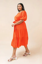 Load image into Gallery viewer, Our India dress is a dress you will want to wear for so many special occasions. This amazing woven midi dress features a square neckline, with non-functional button -down detail, a self-sash tie, elasticized waist and sleeves at shoulders and arm and tiered skirt. A rich coral color makes this dress even more stunning.