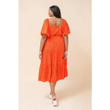 Load image into Gallery viewer, Our India dress is a dress you will want to wear for so many special occasions. This amazing woven midi dress features a square neckline, with non-functional button -down detail, a self-sash tie, elasticized waist and sleeves at shoulders and arm and tiered skirt. A rich coral color makes this dress even more stunning.