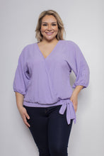Load image into Gallery viewer, A lovely lavender color top, our Leeann faux wrap side tie blouse is a perfect top for every season. With the lightweight linen feel, you will be sure to remain cool and comfortable during those hot, humid days while looking stylish. The details are in the design and this top does not disappoint with its faux wrap front and side tie, stretch banded bottom and 3/4 sleeves. A keyhole button closure is found in the back at the neckline. Color- Lavender. 3/4 sleeves.